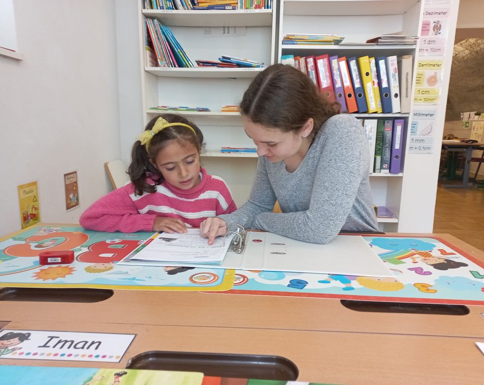 Ein Mädchen und eine Frau beim Lernen an einem Schreibtisch